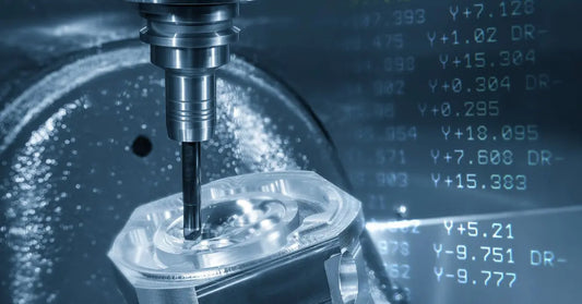 A close-up of a CNC machine drilling a piece of metal. A digital overlay of computer code is off to the right.